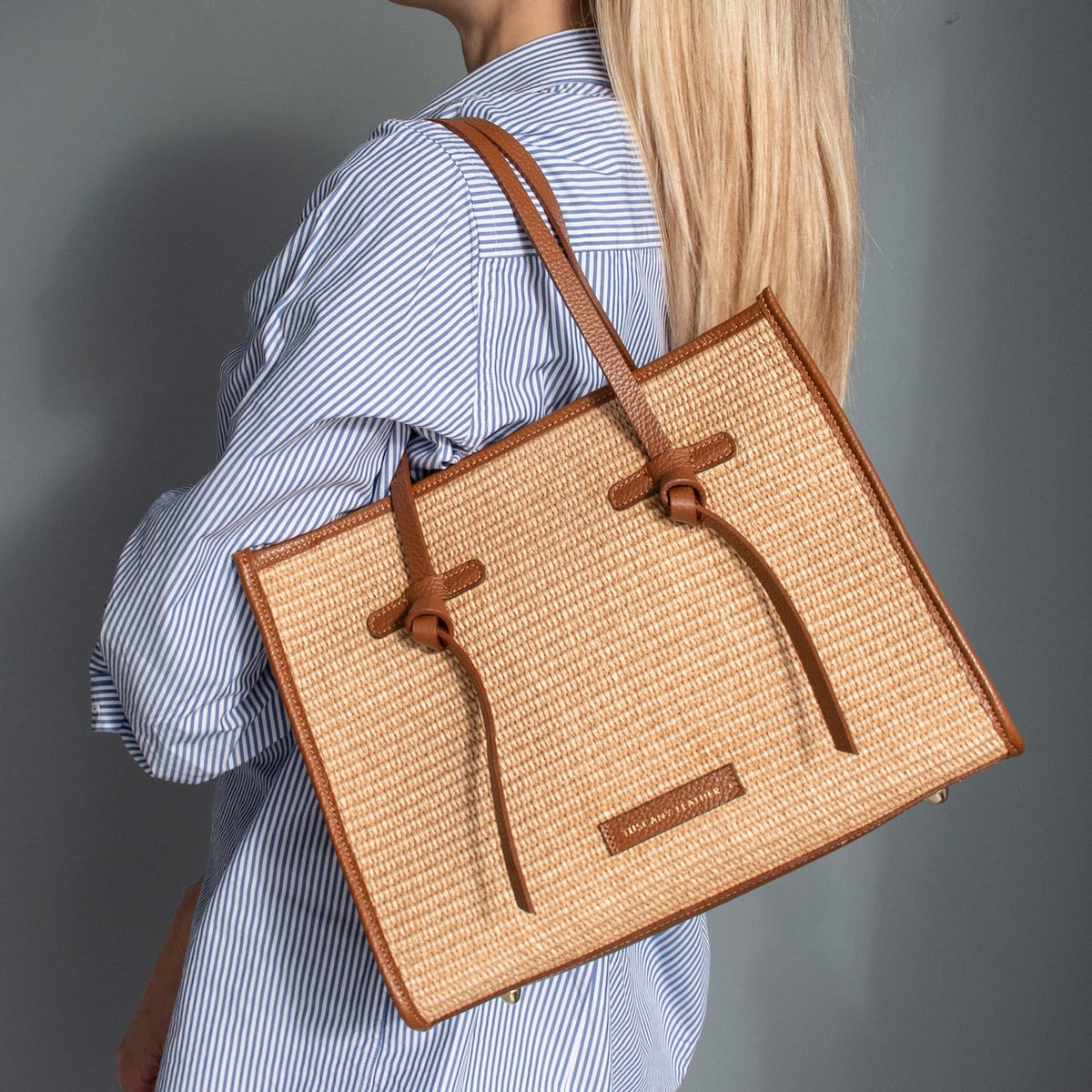 Reccognacfarbengular straw effect shoulder bag with cognacfarben leather trim and handles worn over the shoulder.