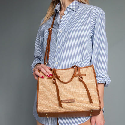 Nahaufnahme of reccognacfarbengular straw effect bag with brown leather trim and Tragegriffe.