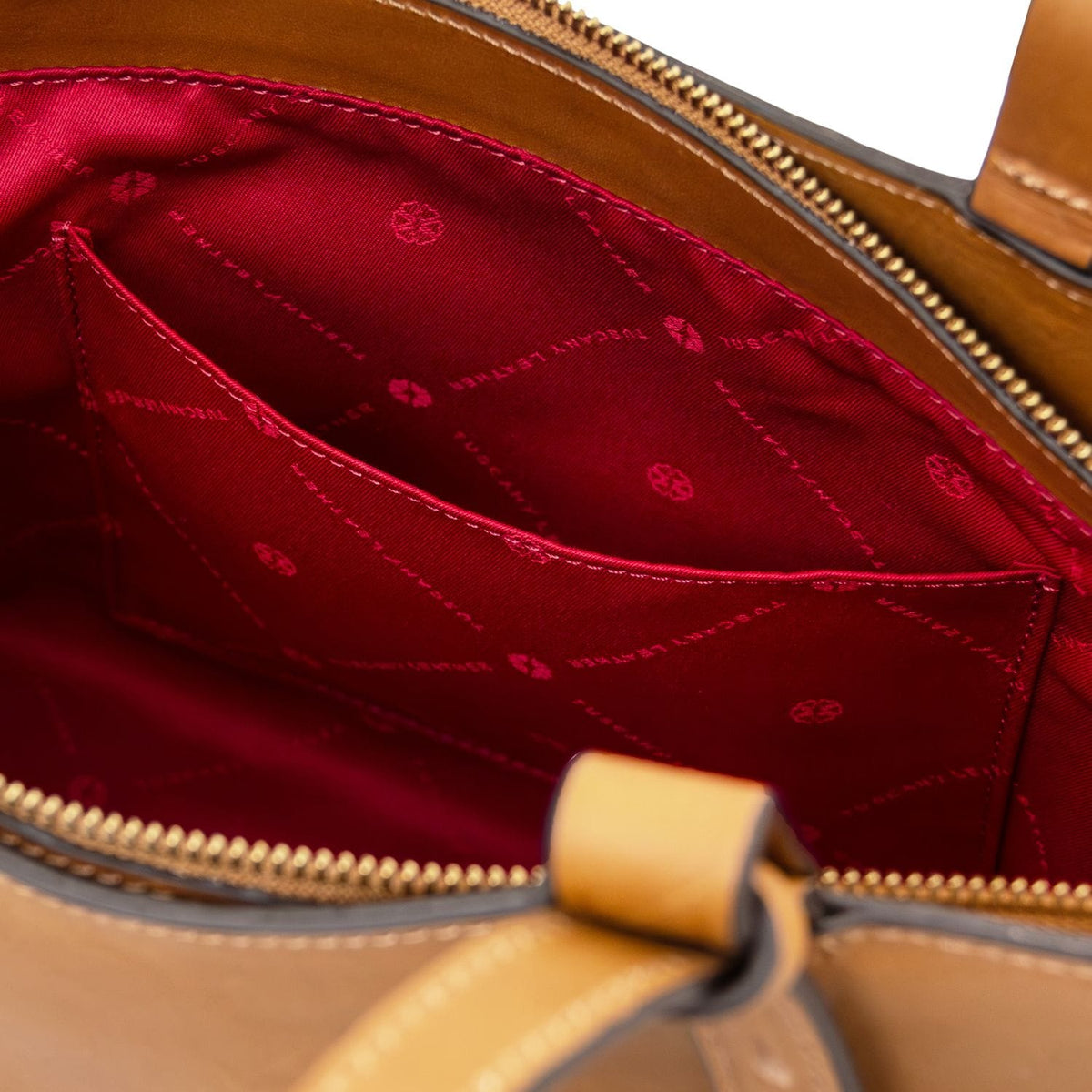 Red lining inside the Libra tote with stitched pocket and visible zipper along the top opening.