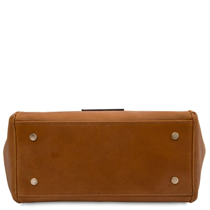 Bottom view of tan Libra tote showing four metal feet and neat stitching