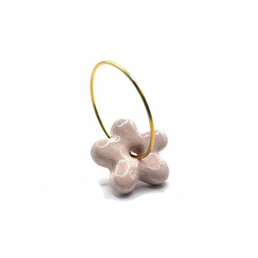 Side view of pink floral ceramic dangle earring on a gold hoop
