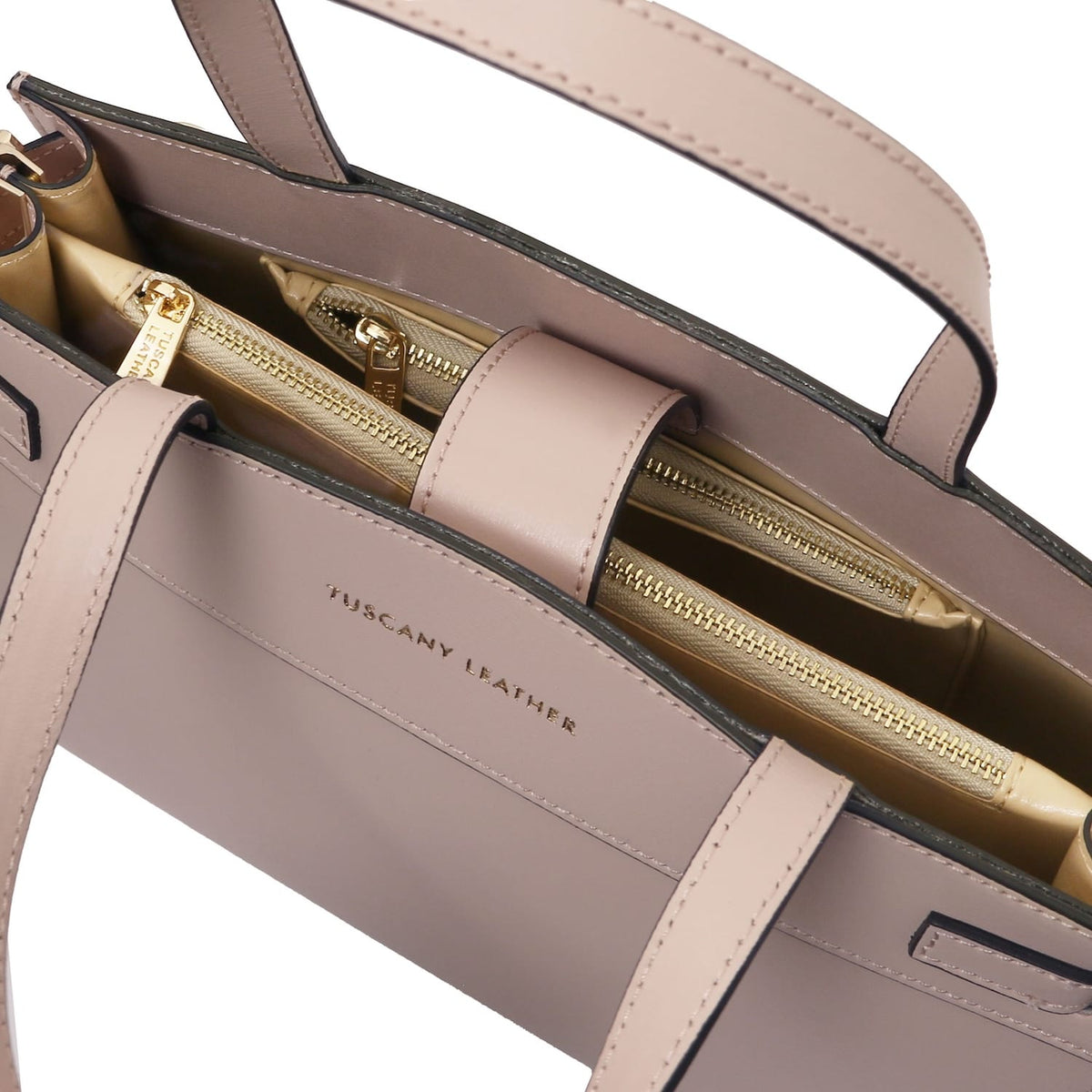 Interior close-up of the Musa handbag with multiple zip pockets and gold hardware.