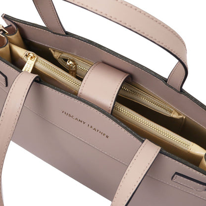 Interior close-up of the Musa handbag with multiple zip pockets and gold hardware.