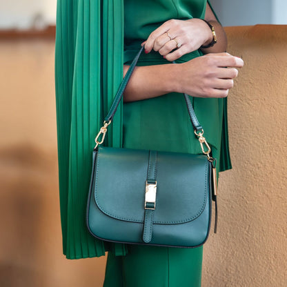 Nausica teal blue leather shoulder bag with gold hardware and adjustable strap worn on the model’s shoulder