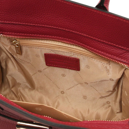 Open red leather tote with beige logo patterned lining and a gold zipper pocket inside.