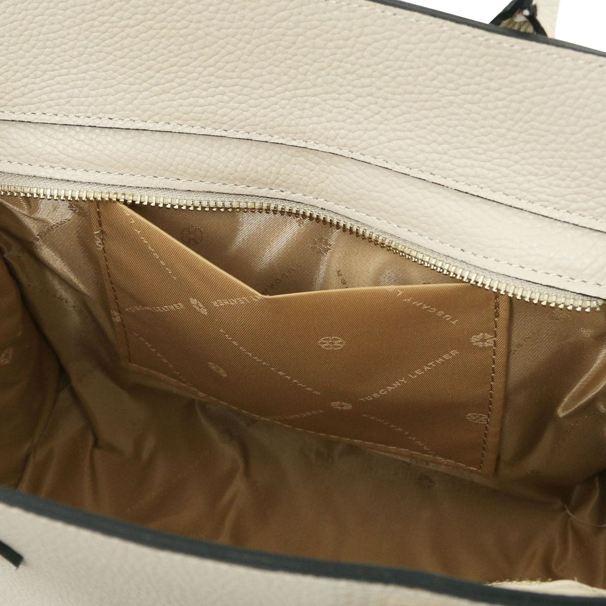 Interior of beige leather tote with tan lining and a zippered pocket