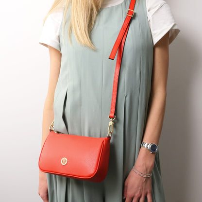 Parfait leather crossbody bag in bright coral con accessori metallici color oro e a long tracolla regolabile worn over the shoulder
