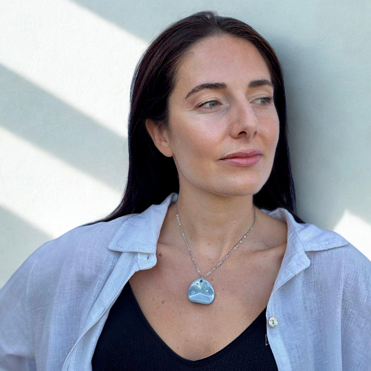 Vista frontale of the azzurro ceramic pendant necklace resting on the model's chest