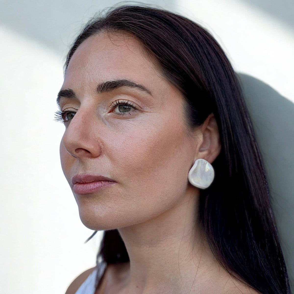 Mannequin porcognact a large pearl white ceramic earring on her ear