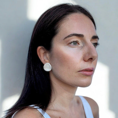 Vue latérale of a femme porcognact a pearl white ceramic stud earring