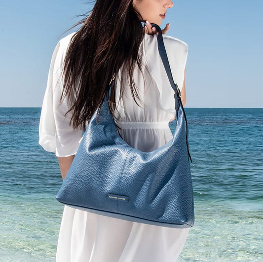 Donna con borsa blu vicino al mare