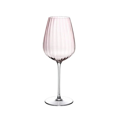 Dusty rose ribbed white wine glass with a long slender stem against white background