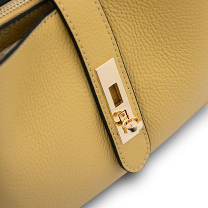 Primo piano of accessori metallici color oro on the mustard leather strap of Soave hebag.