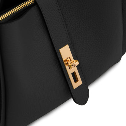 Primo piano of nero pelle martellata hebag con a gold reccuoiogular clasp on the strap