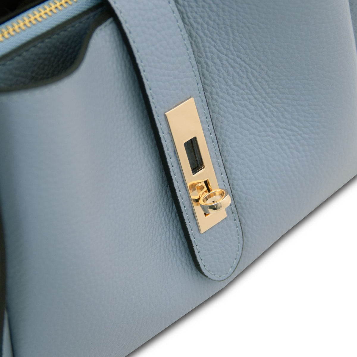 Primo piano of azzurro pallido strap con accessori metallici color oro on Soave hebag.