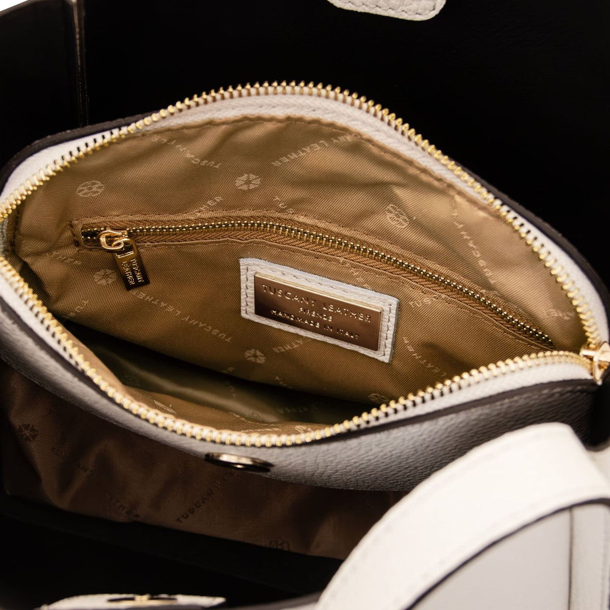 Vista interna of beige hebag con fodera color cuoio gold tasca con zip e bre label.
