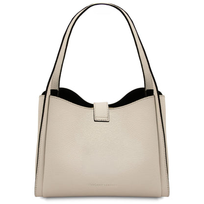 Crema beige pelle morbida hebag con due manici e accessori metallici color oro su sfondo bianco