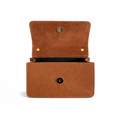 Inside of a brown leather handbag with gold magnetic button sobre fondo blanco