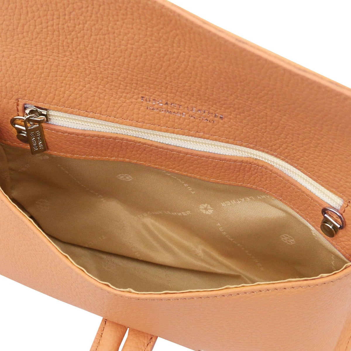 Interior of cognac generfd leer foldover clutch with ritsvak and beige voering.