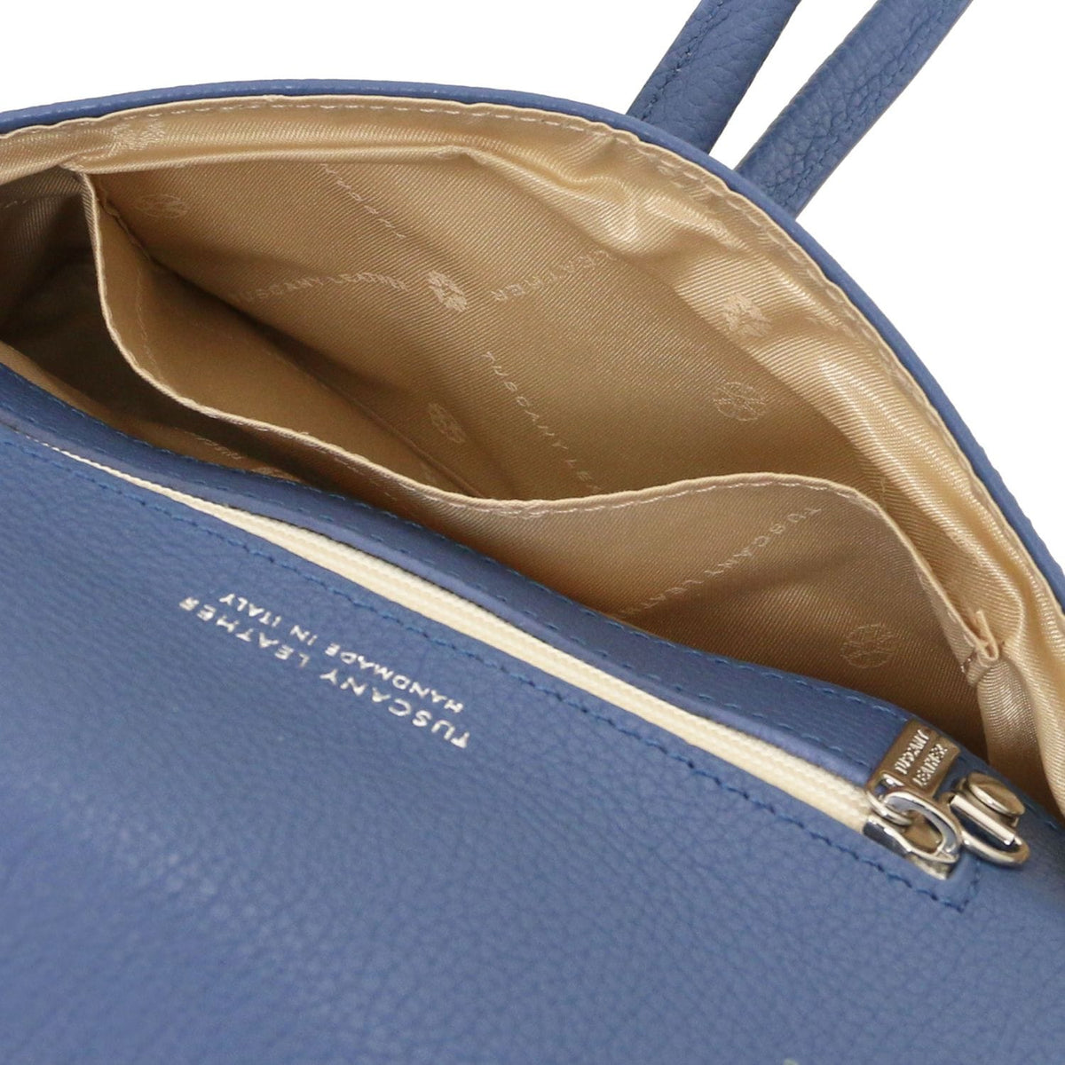 Geopend blue leather clutch with beige patterned lining and internal pocket.