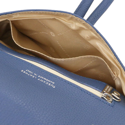 Geopend blue leather clutch with beige patterned lining and internal pocket.
