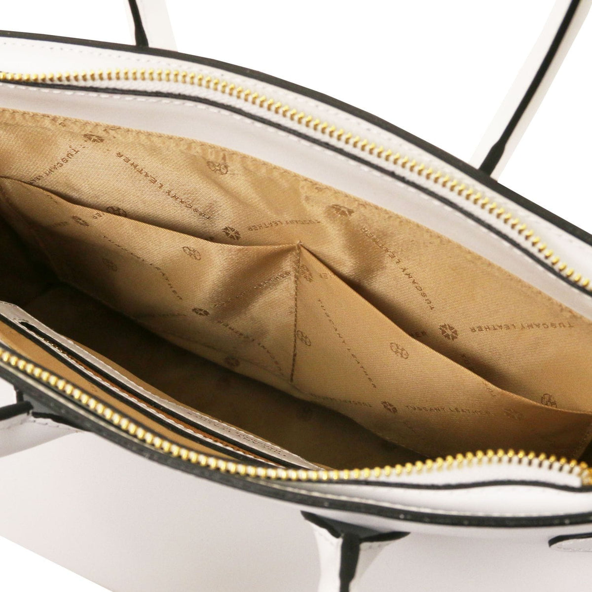 Interior view of leather handbag showing beige fabric lining with logo pattern and internal slip pockets, gold zipper closure visible.
