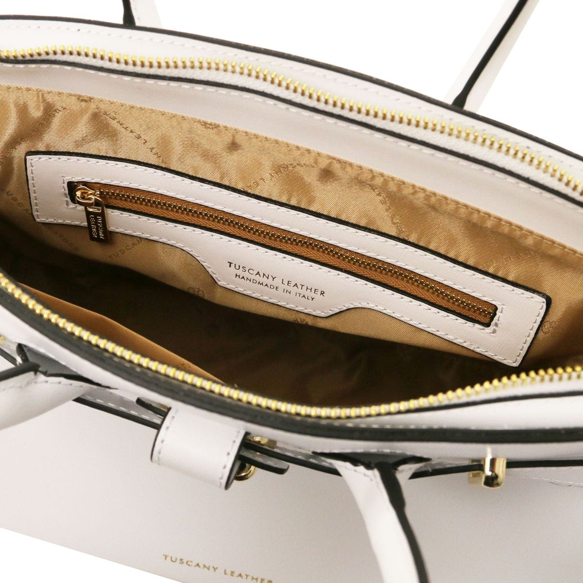 Interior view of white leather handbag with golden zipper pocket and tan fabric lining, handcrafted in Italy.