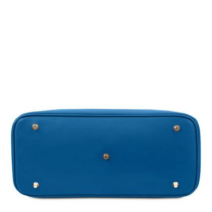 Bottom view of a structured blue leather handbag featuring five protective metal feet on a smooth leather base.