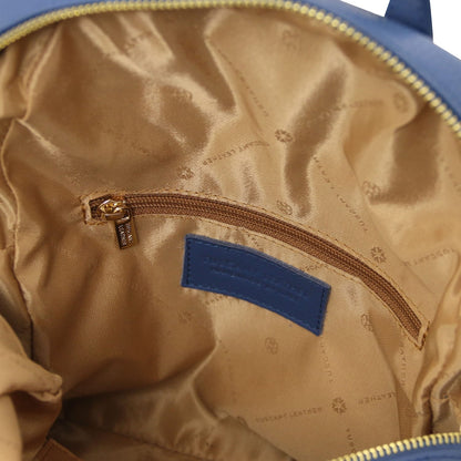 Interior of blue leather backpack with tan lining and zip pocket plus a blue brand label
