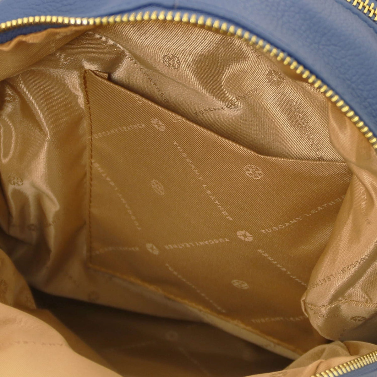 Interior of TL Bag blue leather backpack with tan satin lining and a slip pocket.