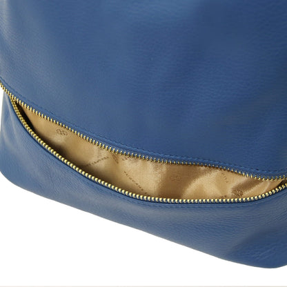 Close-up of blue leather TL Bag backpack exterior with a gold zipper along a curved opening.