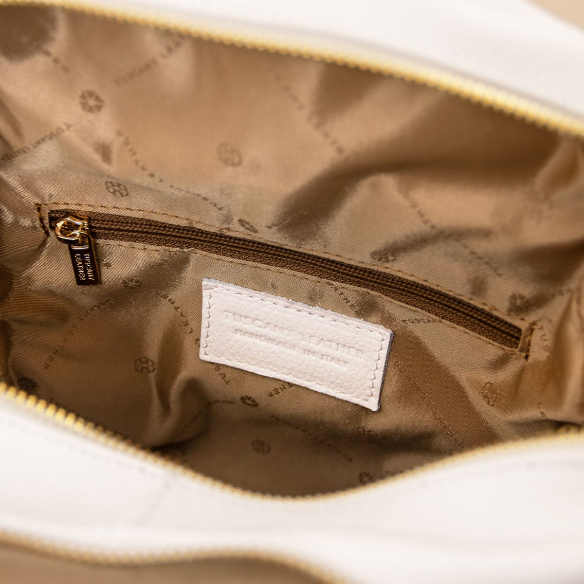 Inside view showing brown zip pocket and white stitched brand label in TL Bag leather backpack