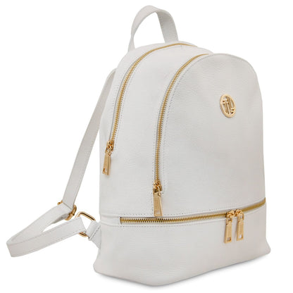 White soft leather backpack with gold zippers, circular front logo badge, top handle and adjustable straps.