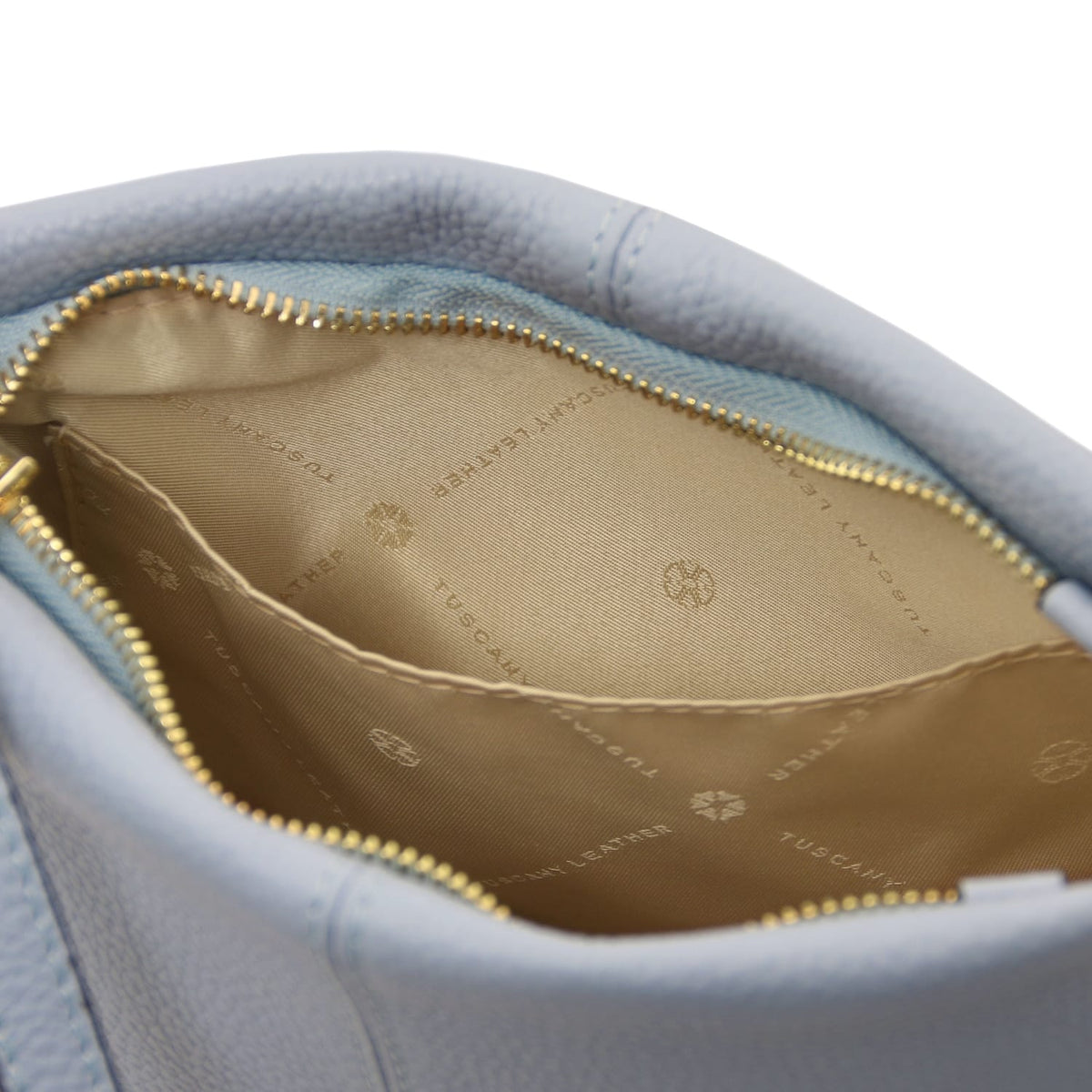 Aperto view of soft pebbled azzurro leather shoulder bag showcasing beige fodera interna con logo print e open pocket detail.