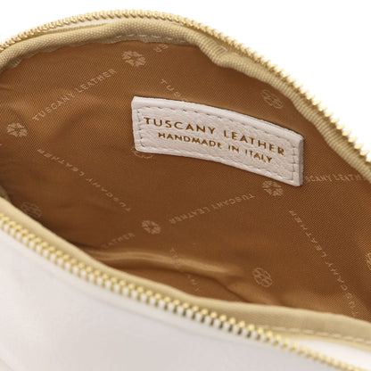Primo piano of beige leather toiletry case interior featuring breed fodera in tessuto e stitched Tuscany Leather label inside zipper opening.