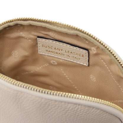 Primo piano of beige pelle morbida toiletry case interior con fodera in tessuto e Tuscany Leather "Hemade in Italy" label.