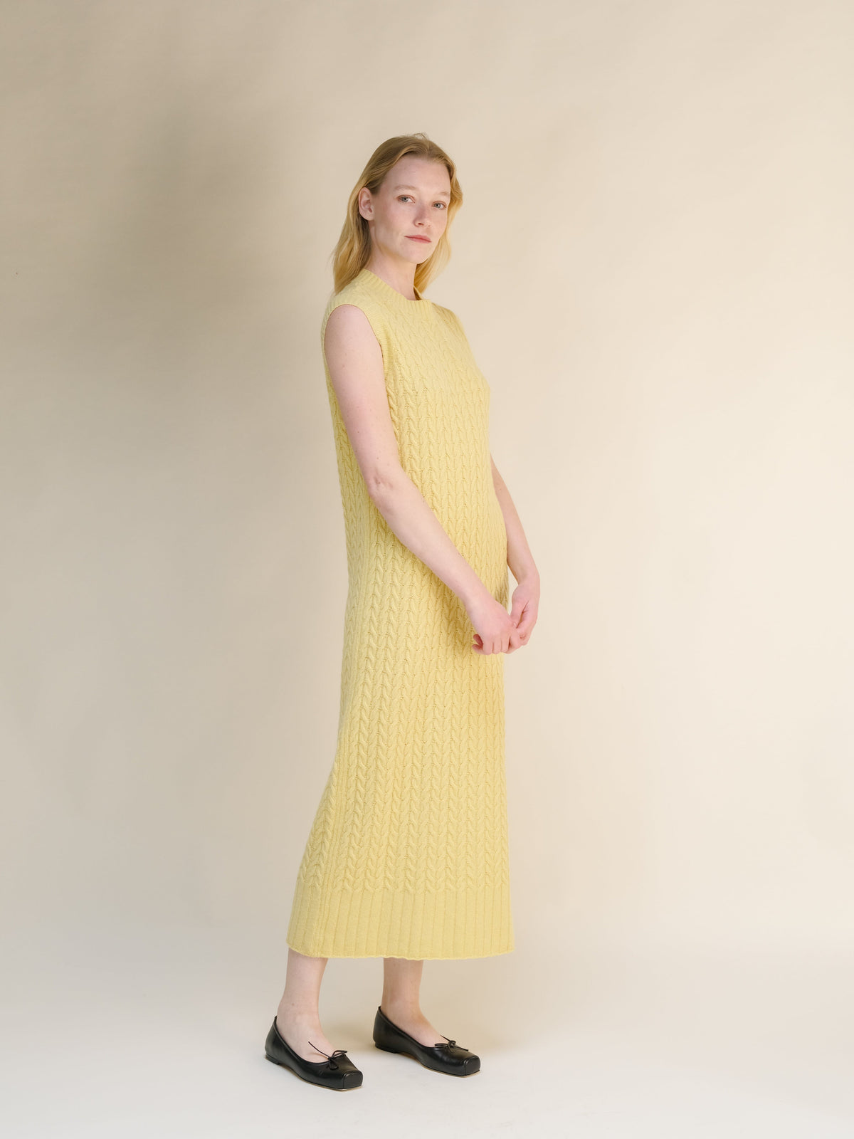 Abito senza maniche a trecce in misto lana e cashmere in soft yellow con texturosso knit pattern e orlo a coste in a long midi length.